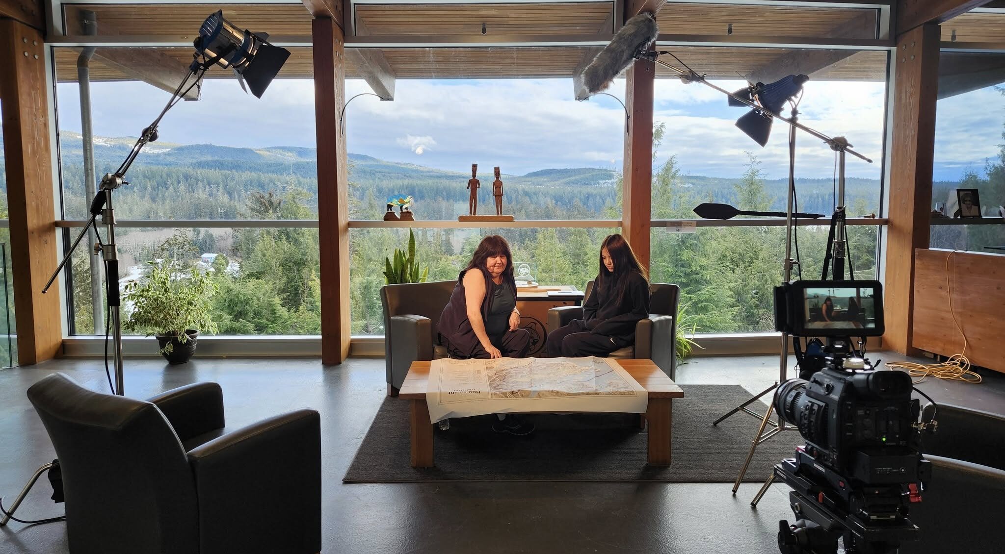 Behind the scenes: a documentary interview set up with lights, boom mic and camera overlooking the coast